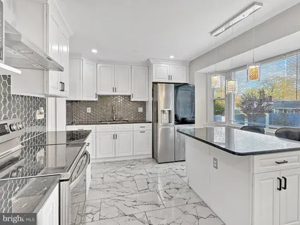 a kitchen with stainless steel appliances granite countertop a sink stove refrigerator and cabinets