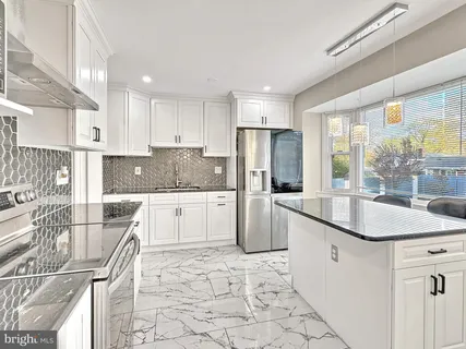 a kitchen with a sink a stove a refrigerator and cabinets