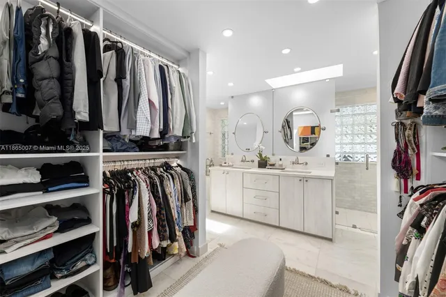 a bedroom with two beds a chandelier and a large window