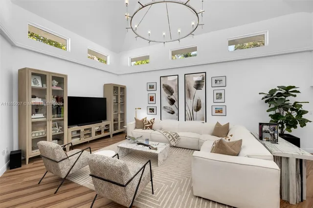 a living room with furniture a potted plant and a wooden floor