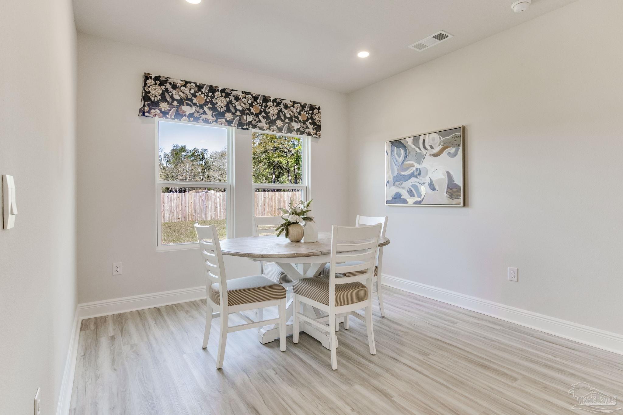 3423 Crossvine Road Cantonment, FL 32533 - Photo 14 of 35 a dining room with wooden floor and a window