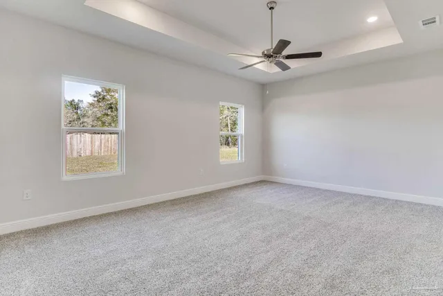 an empty room with windows and fan