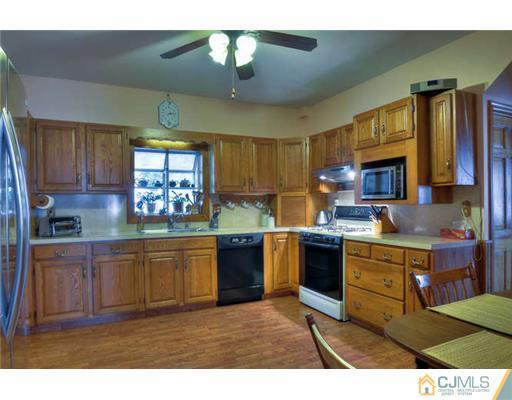 608 Ridge Road Monmouth Junction, NJ 08852 - Photo 6 of 16 a kitchen with stainless steel appliances granite countertop a refrigerator a sink dishwasher a stove and a dining table with wooden floor