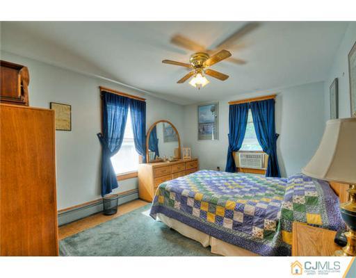 608 Ridge Road Monmouth Junction, NJ 08852 - Photo 8 of 16 a bedroom with a bed a dresser and a chandelier