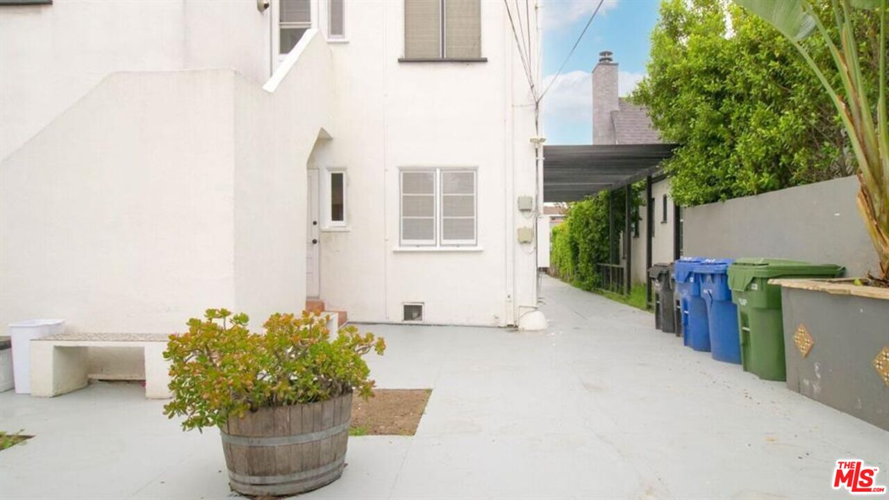 1437 South Ridgeley Drive Los Angeles, CA 90019 - Photo 12 of 37 a potted plant sitting in front of a house