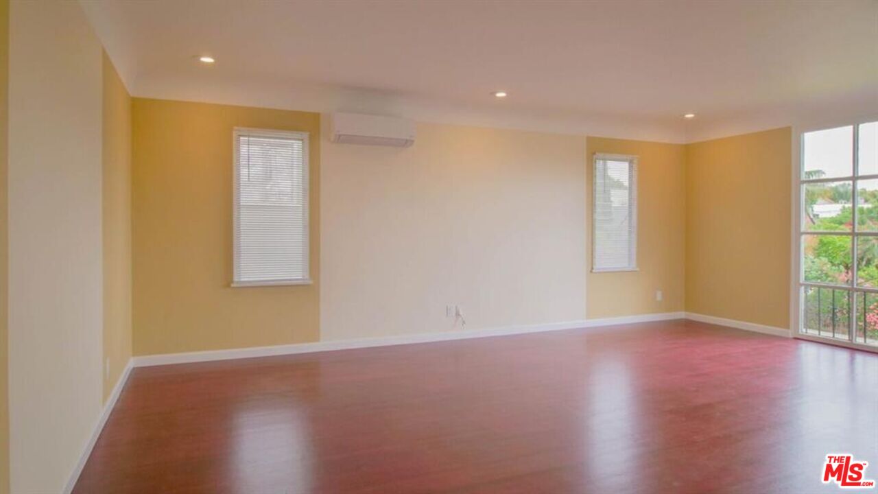 1437 South Ridgeley Drive Los Angeles, CA 90019 - Photo 15 of 37 a view of empty room with wooden floor and fan