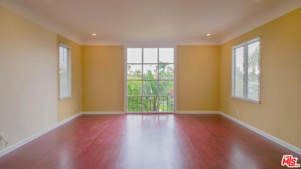 1437 South Ridgeley Drive Los Angeles, CA 90019 - Photo 16 of 37 a view of an empty room with wooden floor and a window