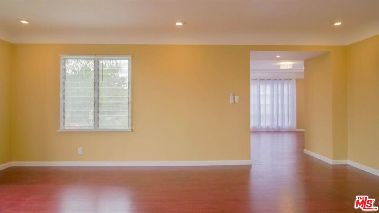 1437 South Ridgeley Drive Los Angeles, CA 90019 - Photo 18 of 37 a view of an empty room with wooden floor and a window