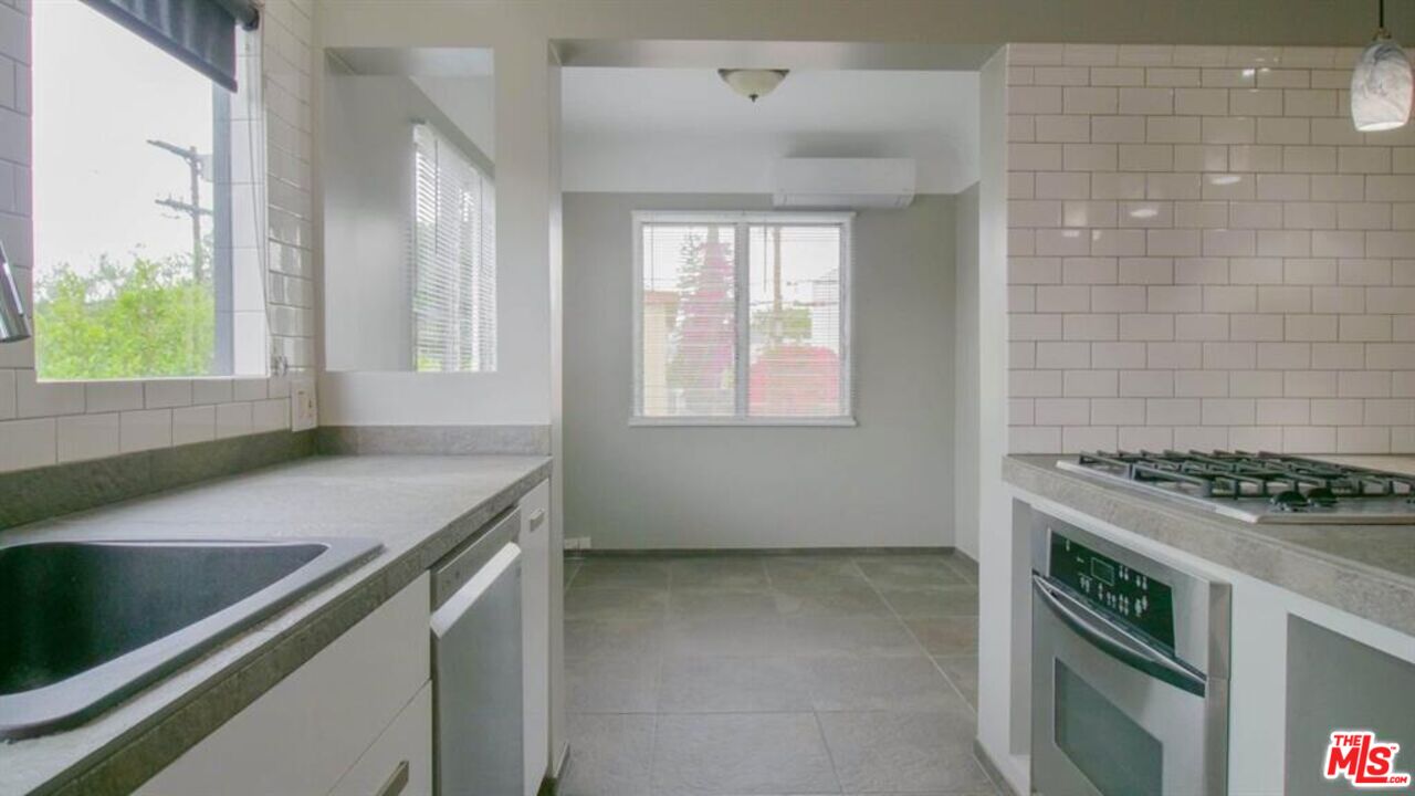 1437 South Ridgeley Drive Los Angeles, CA 90019 - Photo 21 of 37 a kitchen that has a sink and a stove