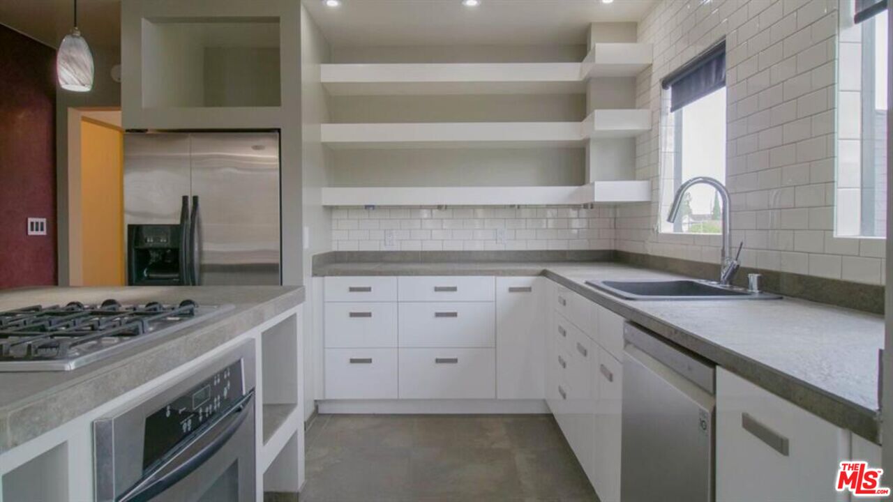 1437 South Ridgeley Drive Los Angeles, CA 90019 - Photo 23 of 37 a kitchen with cabinets appliances and a counter space