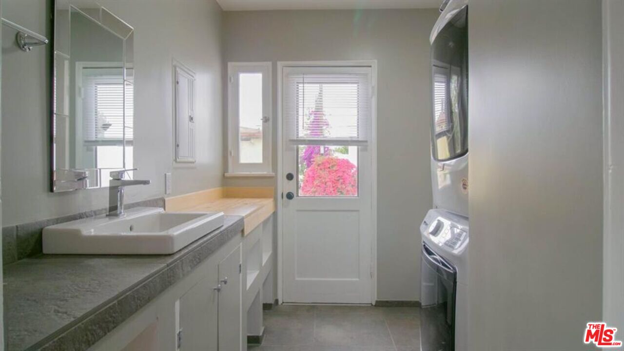 1437 South Ridgeley Drive Los Angeles, CA 90019 - Photo 24 of 37 a bathroom with a granite countertop sink and a mirror