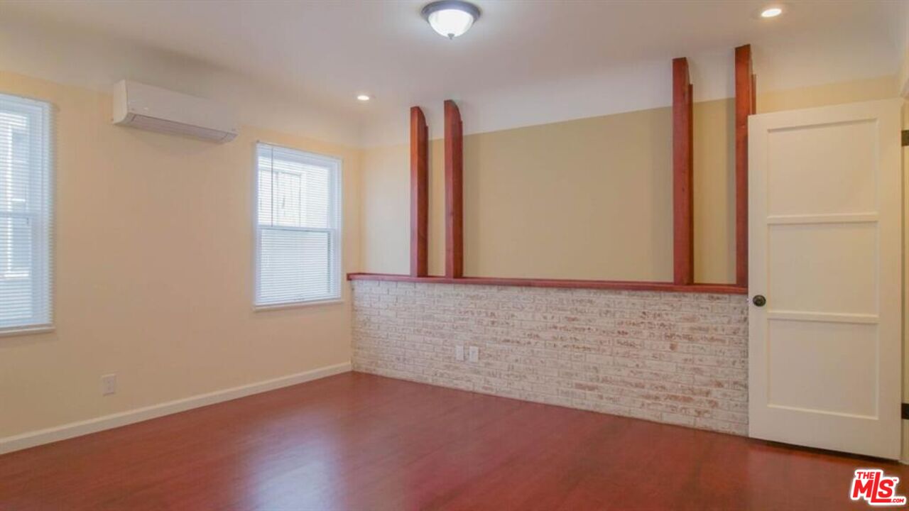 1437 South Ridgeley Drive Los Angeles, CA 90019 - Photo 27 of 37 an empty room with wooden floor and windows