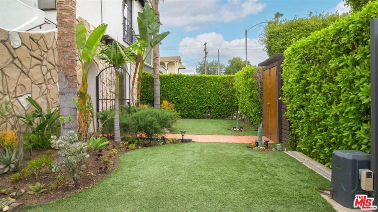 1437 South Ridgeley Drive Los Angeles, CA 90019 - Photo 3 of 37 a view of a garden with a building in the background
