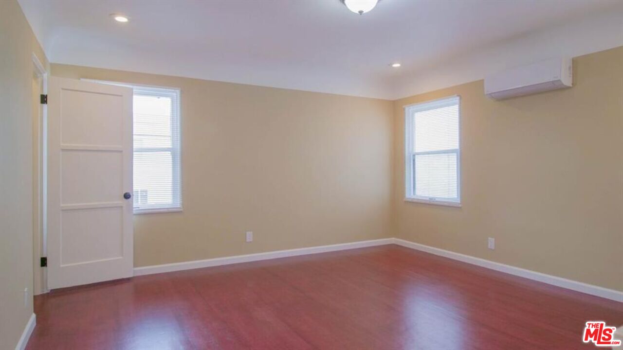 1437 South Ridgeley Drive Los Angeles, CA 90019 - Photo 31 of 37 an empty room with wooden floor and windows