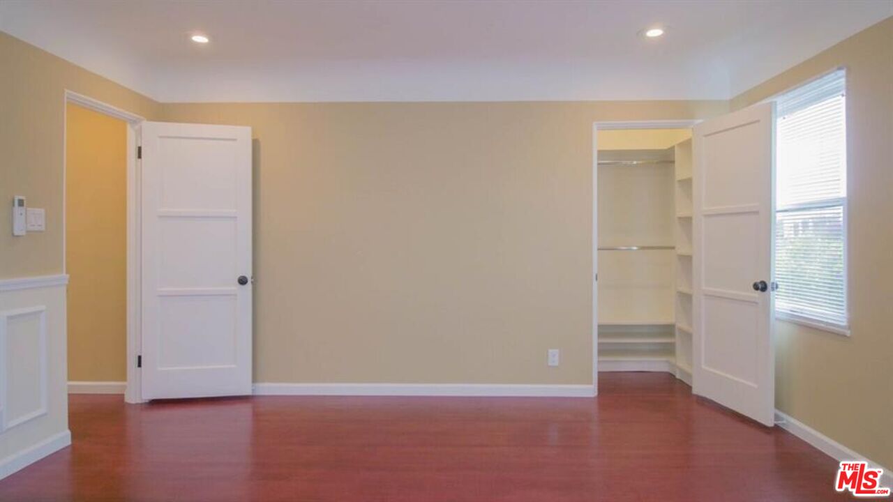 1437 South Ridgeley Drive Los Angeles, CA 90019 - Photo 33 of 37 a view of an empty room with wooden floor and a window