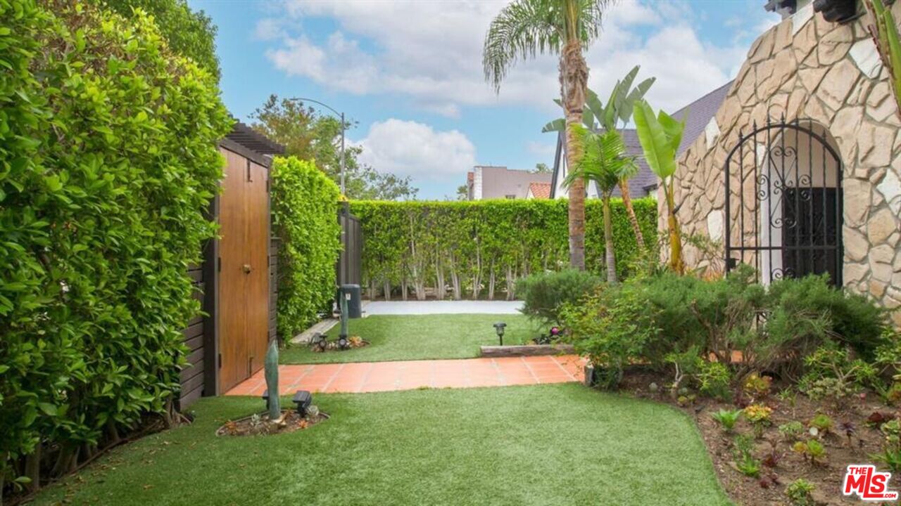 1437 South Ridgeley Drive Los Angeles, CA 90019 - Photo 5 of 37 a view of a garden with a building in the background