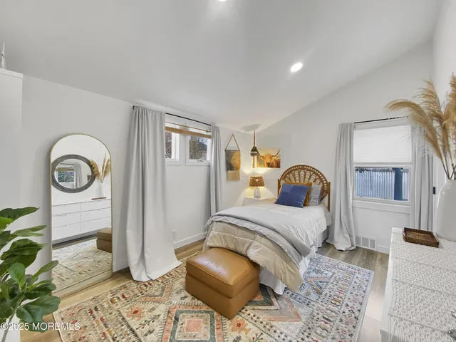 a bedroom with a bed and a mirror on dresser