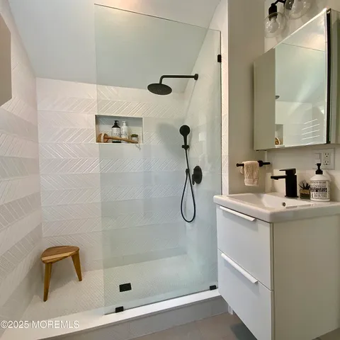 a bathroom with a shower a mirror and a shower