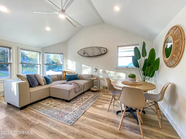 a living room with furniture a rug potted plant and a window