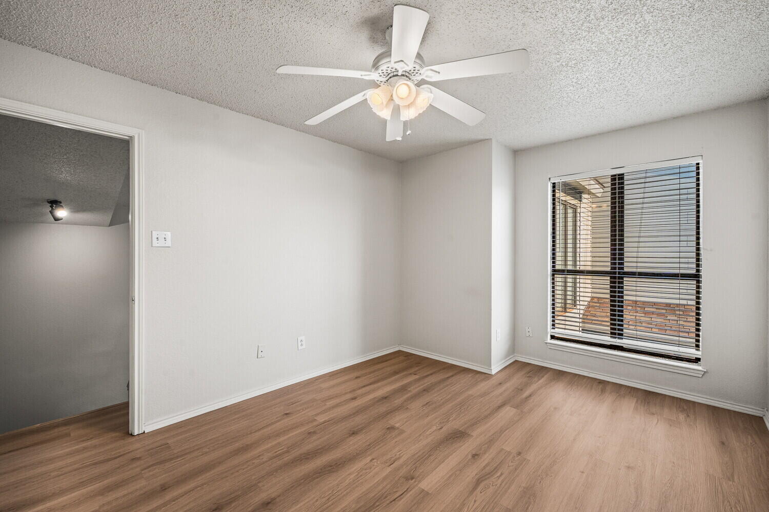 534 North Fulton Avenue Lubbock, TX 79416 - Photo 17 of 24 an empty room with wooden floor chandelier fan and windows