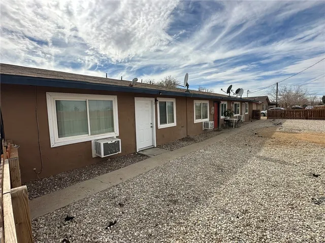 a view of a house with a yard and wooden fence