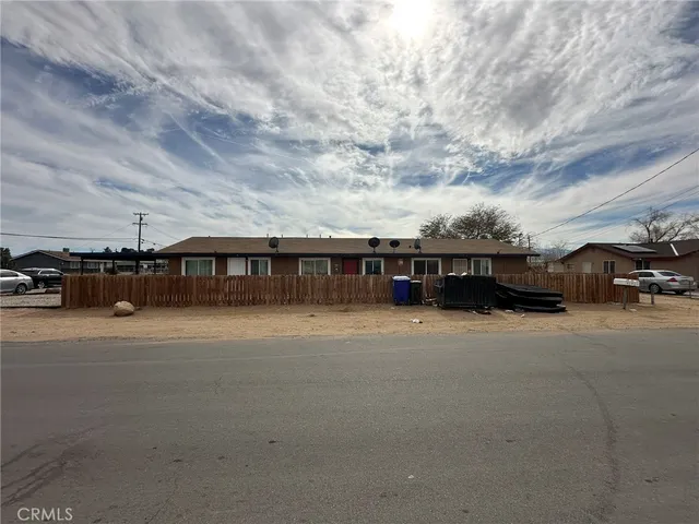 a front view of a house with cars parked