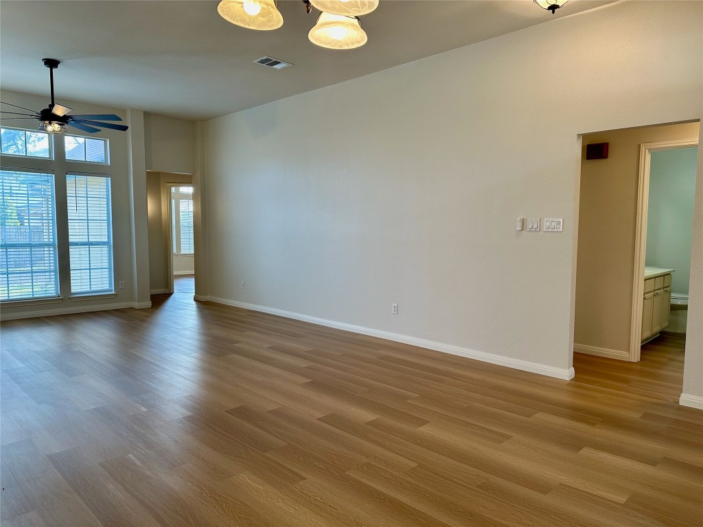 104 Benchmark Street Georgetown, TX 78626 - Photo 12 of 39 an empty room with wooden floor and windows