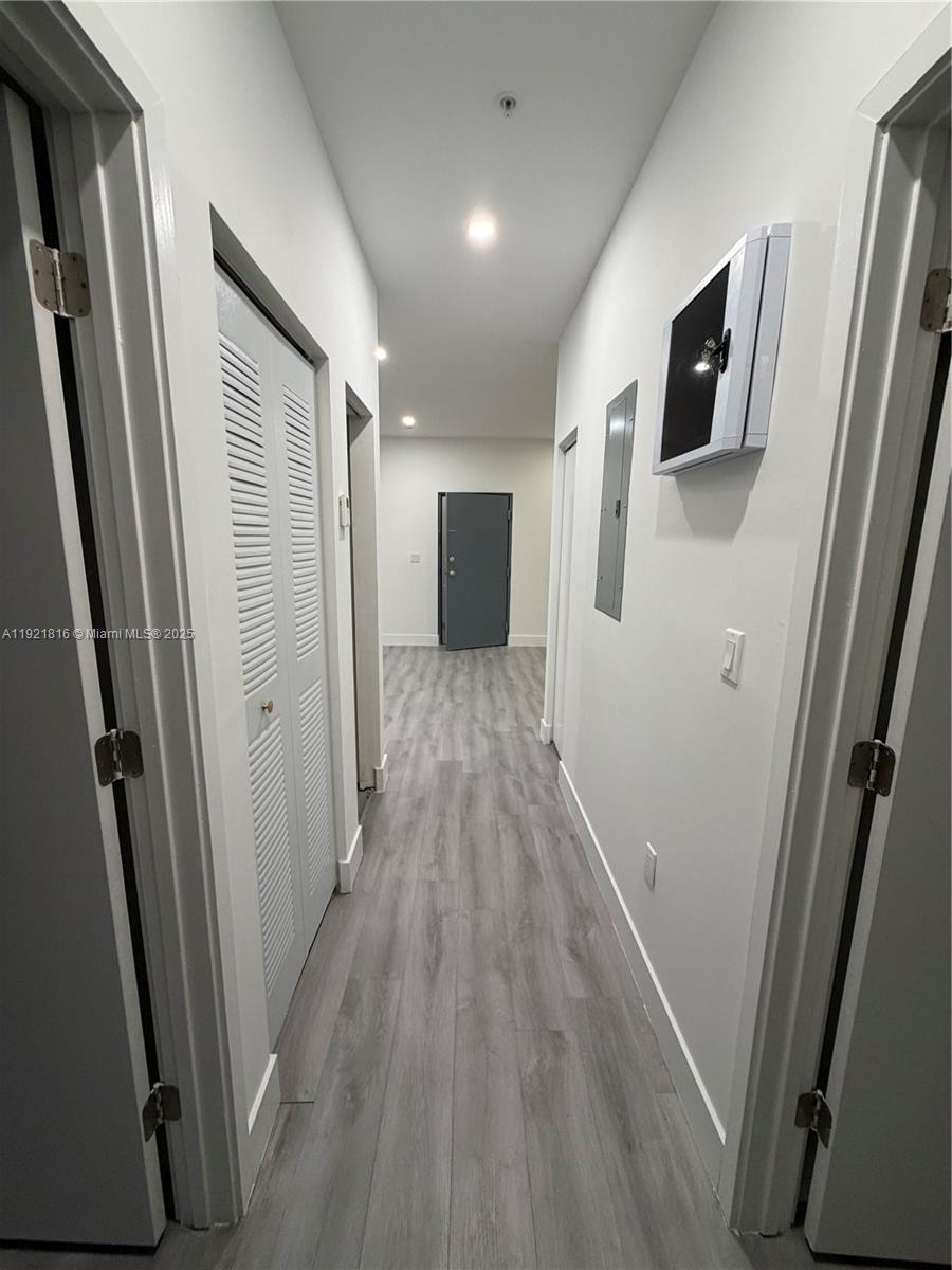 859 East 24th Street, Unit 402 Hialeah, FL 33013 - Photo 11 of 22 a view of a hallway with wooden floor and staircase