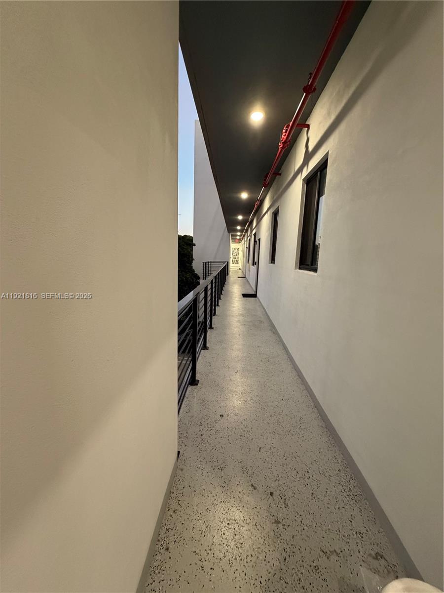 859 East 24th Street, Unit 402 Hialeah, FL 33013 - Photo 13 of 22 a view of a hallway with wooden floor and staircase