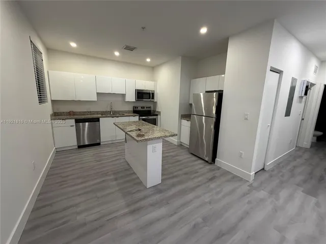 a kitchen with stainless steel appliances a refrigerator and a stove top oven