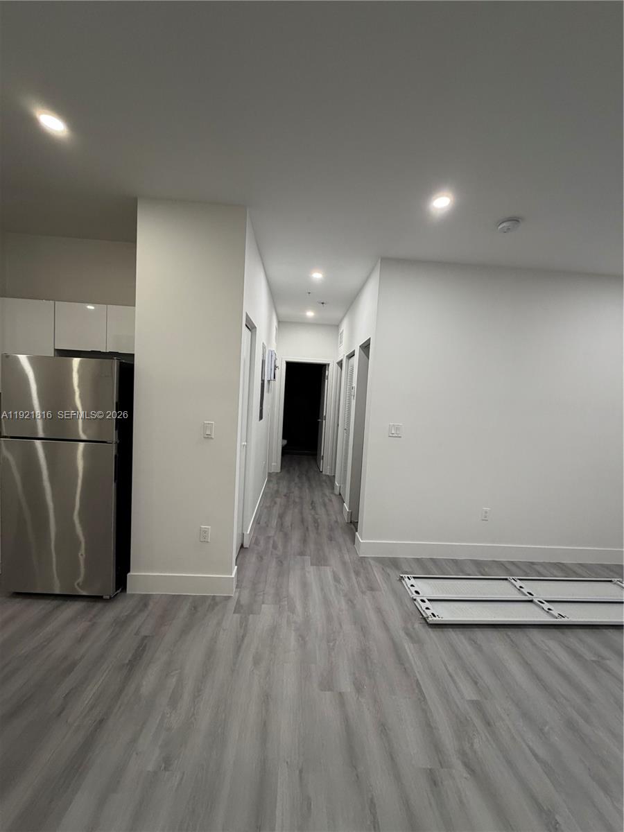 859 East 24th Street, Unit 402 Hialeah, FL 33013 - Photo 3 of 22 an empty room with wooden floor and white walls