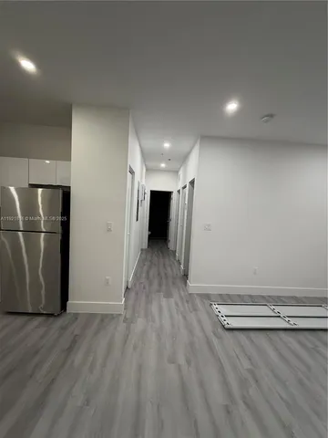 an empty room with wooden floor and a view of room