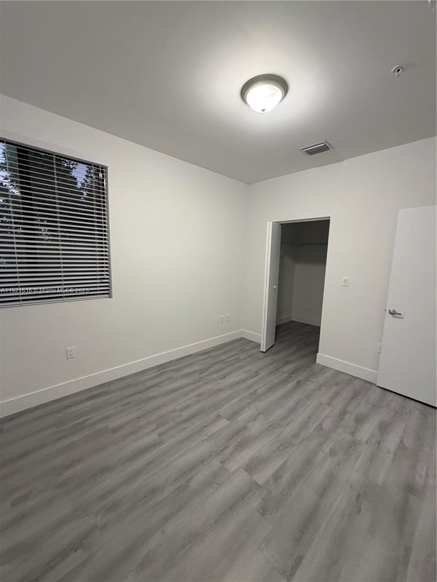 859 East 24th Street, Unit 402 Hialeah, FL 33013 - Photo 7 of 22 a view of an empty room with wooden floor and a window