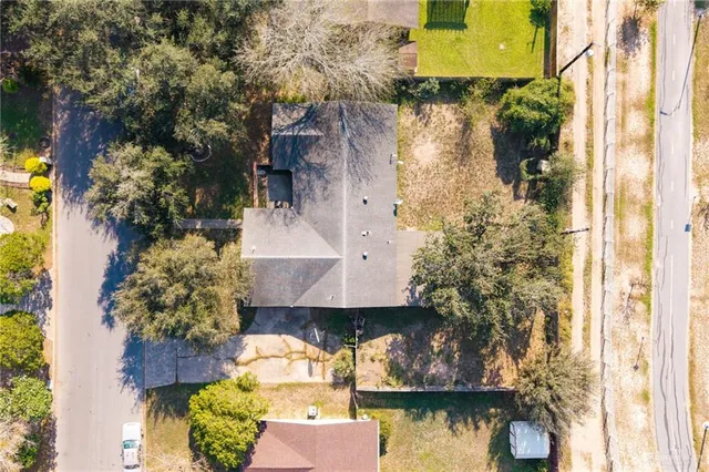 a aerial view of a house with a yard and a large tree in front