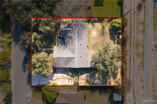 an aerial view of a house with a yard and large tree