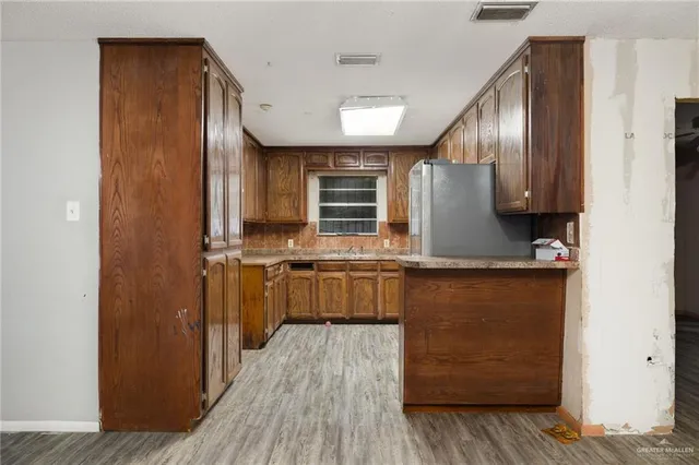 a kitchen with stainless steel appliances granite countertop wooden cabinets a refrigerator and a sink