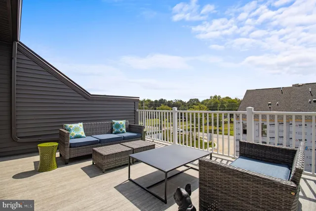 a roof deck with wooden floor and fence