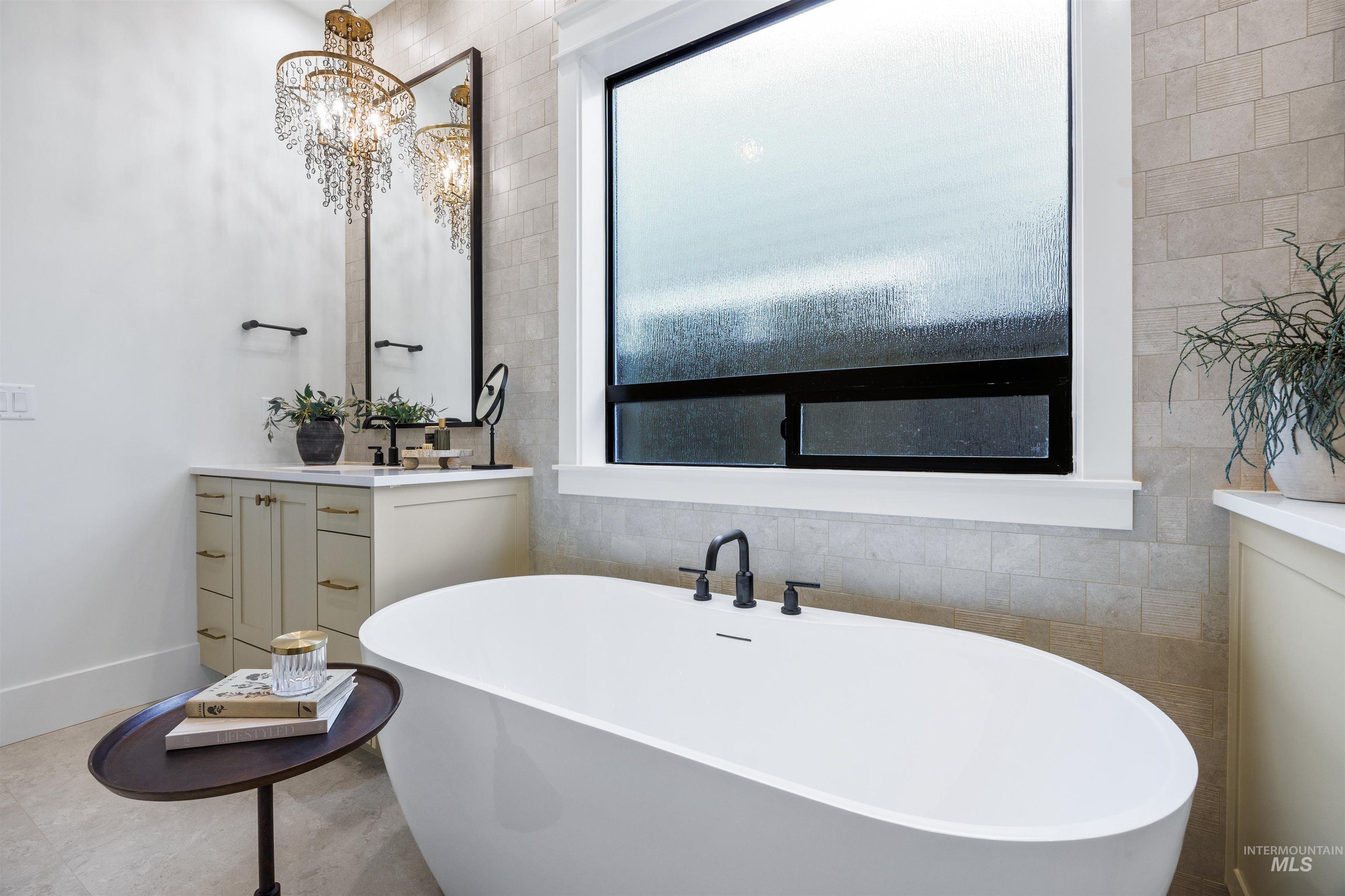 948 East Escalation Street Meridian, ID 83642 - Photo 29 of 44 Full bath featuring vanity, a freestanding tub, tile walls, and suspended lighting