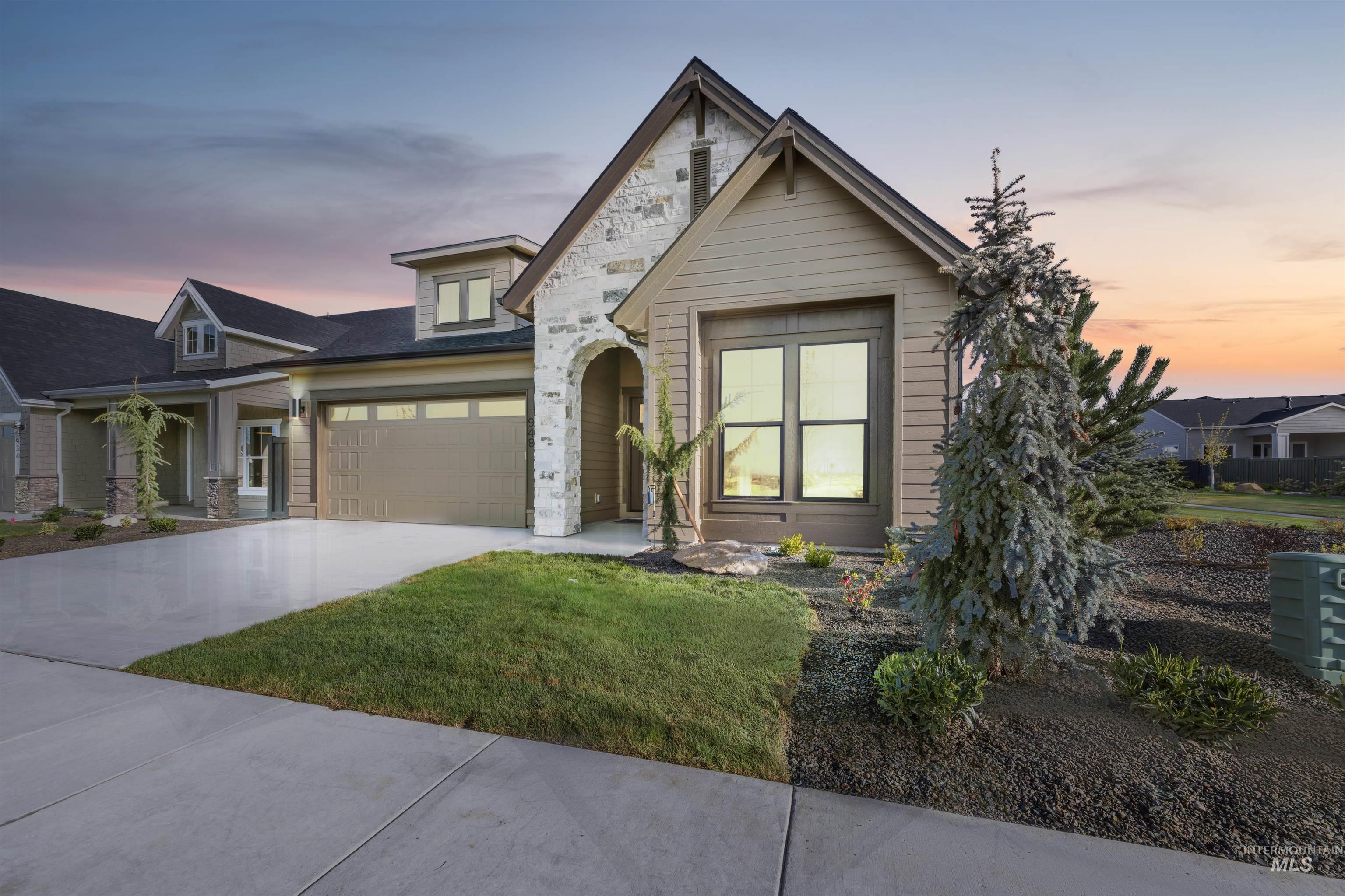 948 East Escalation Street Meridian, ID 83642 - Photo 3 of 44 View of front facade with driveway, a yard, and stone siding