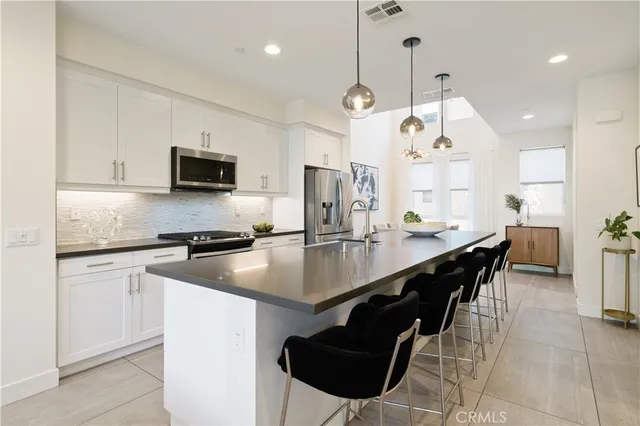 a living room with furniture a clock and a potted plant