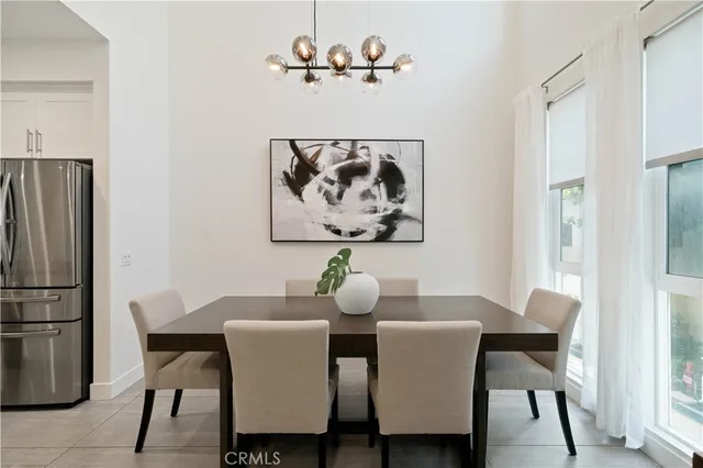 a kitchen with stainless steel appliances a dining table chairs and refrigerator