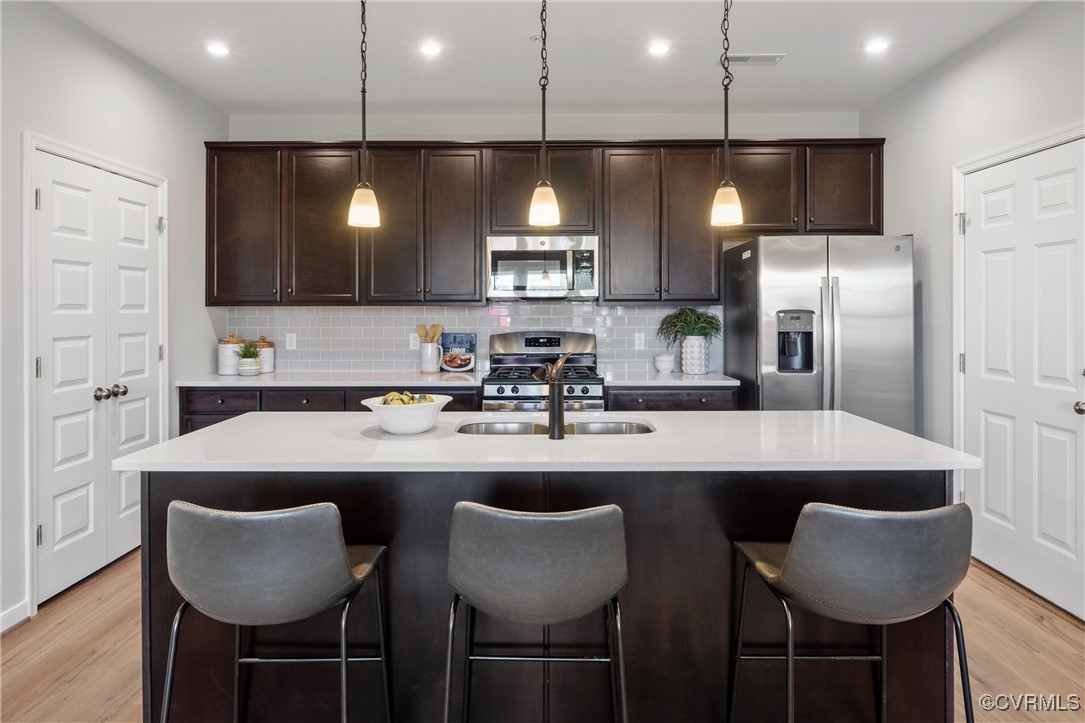 4112 Ebbies Crossing Midlothian, VA 23112 - Photo 7 of 38 a kitchen with stainless steel appliances granite countertop a sink a microwave a refrigerator and chairs