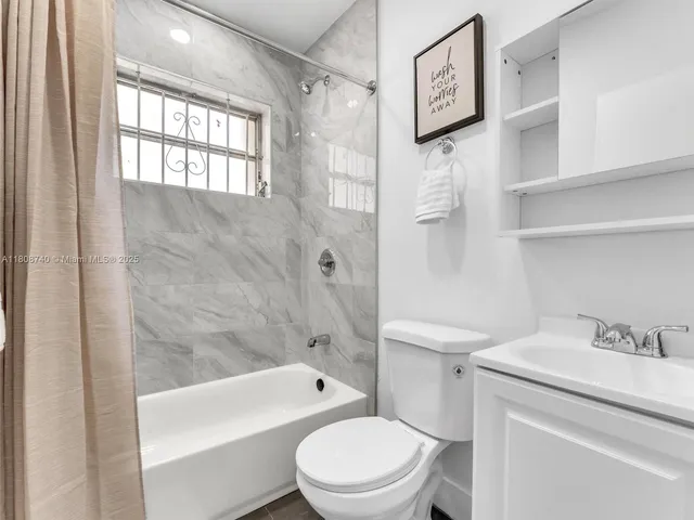 a bathroom with a toilet sink vanity tub and shower