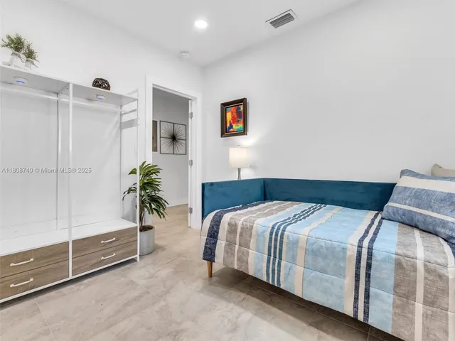 a bedroom with a bed and a potted plant