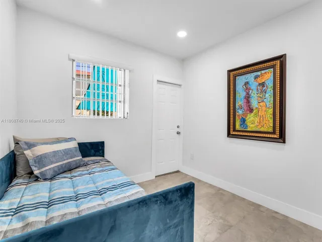 a bedroom with a bed and a painting on the wall