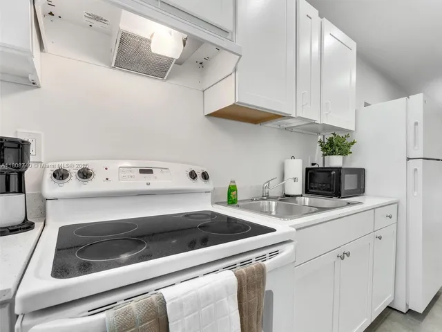 a kitchen with white cabinets and white appliances