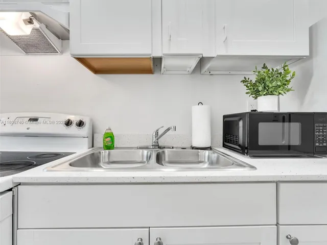 a kitchen with granite countertop a sink and a stove top oven