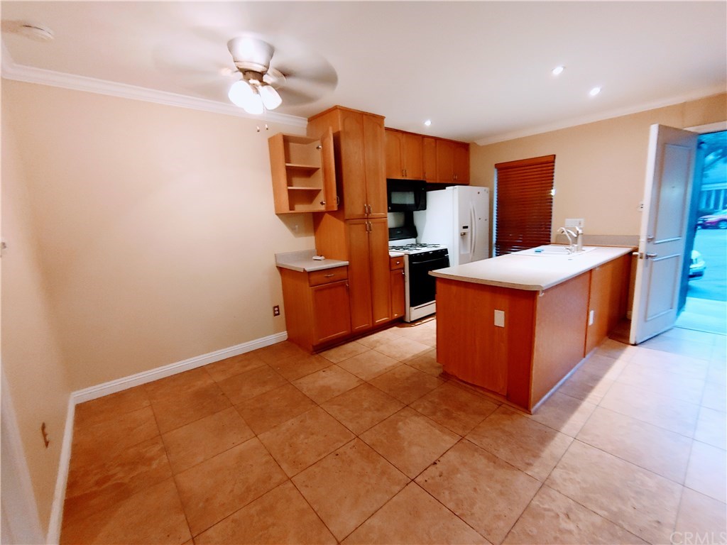 2811 South Fairview Street Santa Ana, CA 92704 - Photo 2 of 24 Dinette area on your left with ceiling fan. Remodeled kitchen with wood cabinetry, recessed lighting.