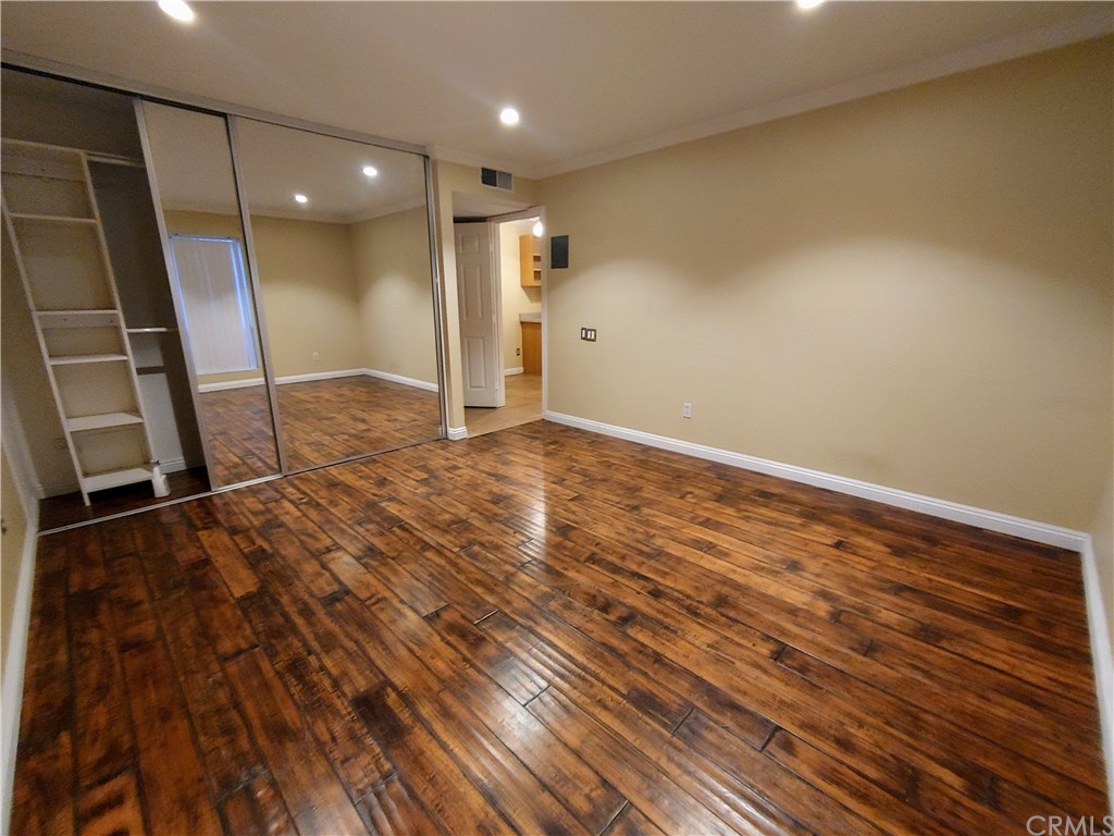 2811 South Fairview Street Santa Ana, CA 92704 - Photo 10 of 24 Large Bedroom, hardwood floor, mirrored closet w/ organizer. Slight view of kitchen if doors are open.