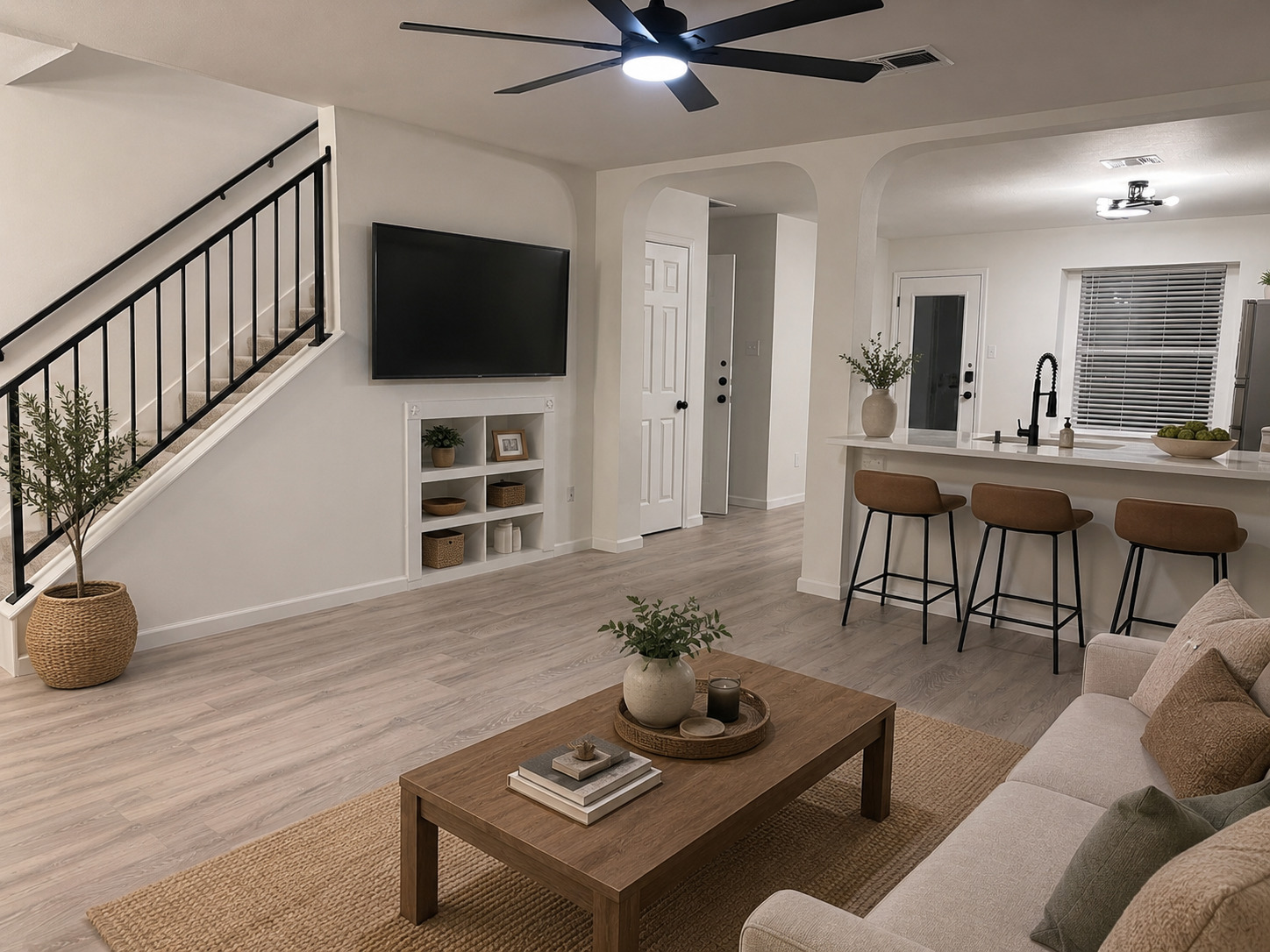 360 Sampson Kyle, TX 78640 - Photo 5 of 36 This is an AI rendering of the living room - Open-concept living space featuring wood-finish flooring, a contemporary ceiling fan, and built-in shelving